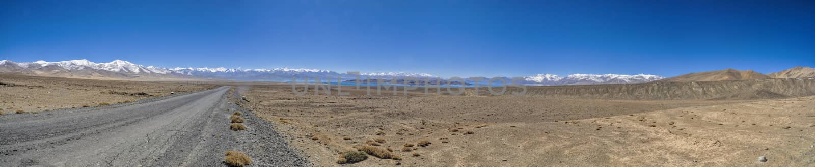 Scenic panorama of road leading through arid landscape in Tajikistan
