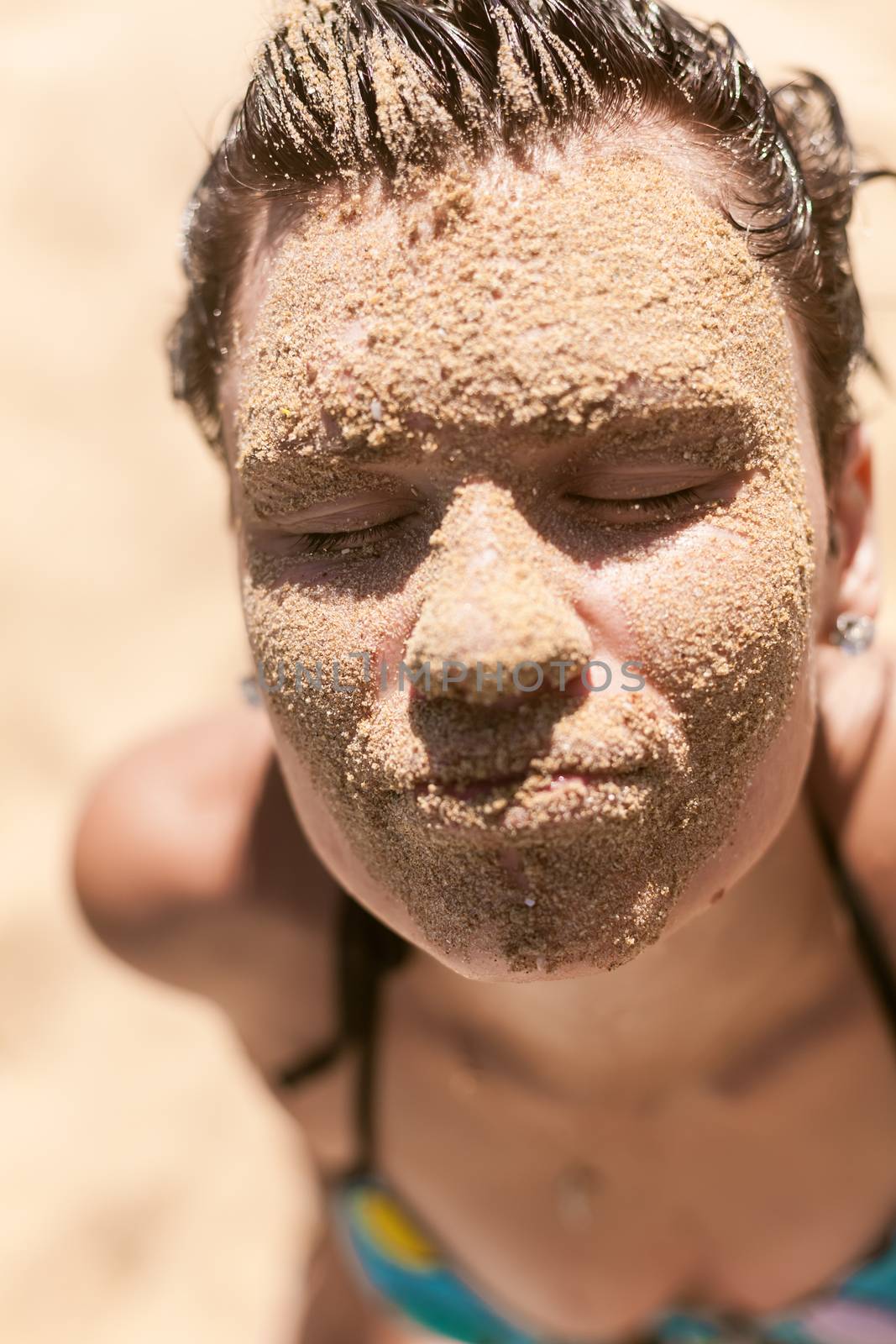 Beautiful girl with sand on face by sarymsakov