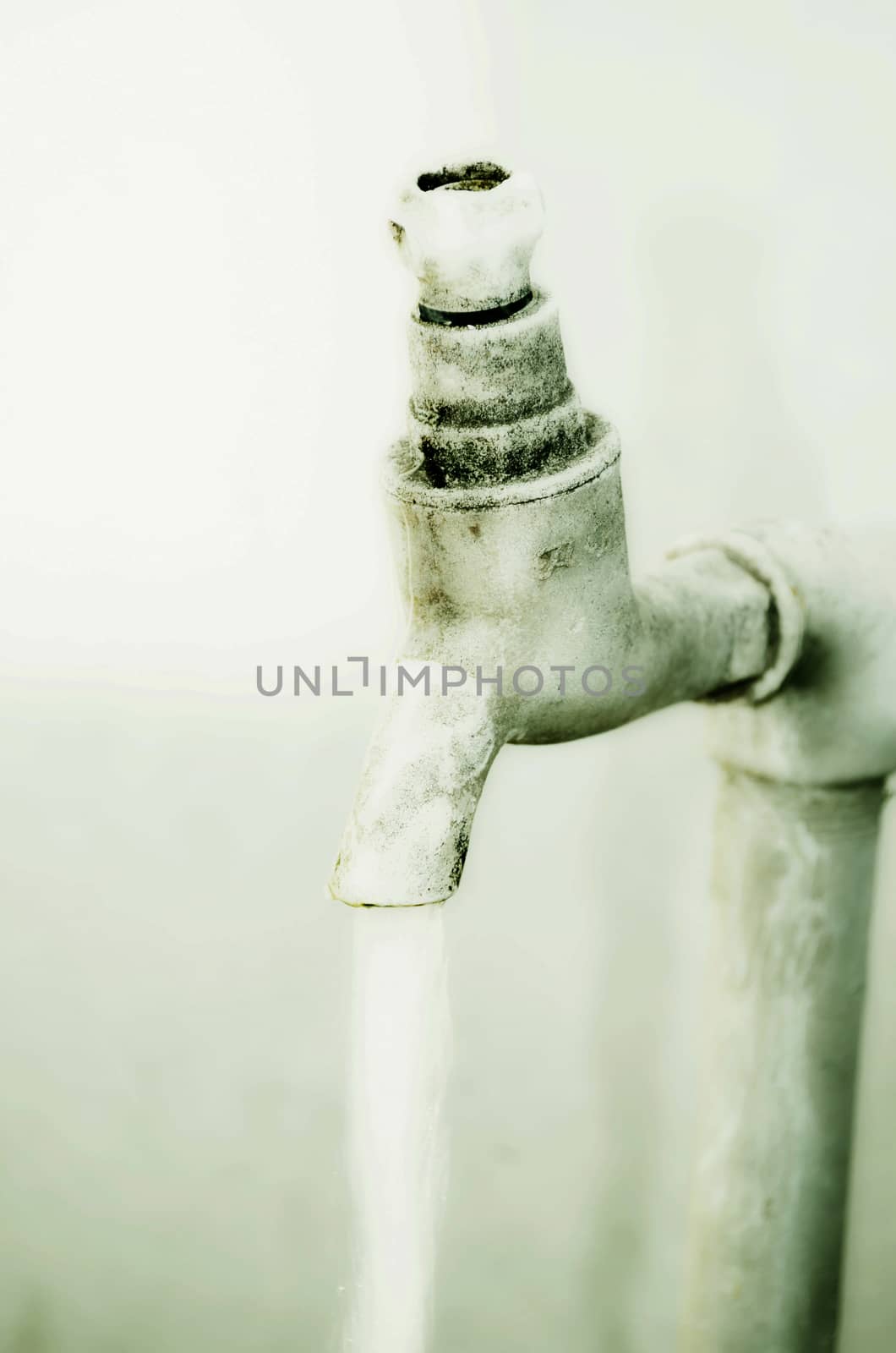 Tap of running water isolated on grey background