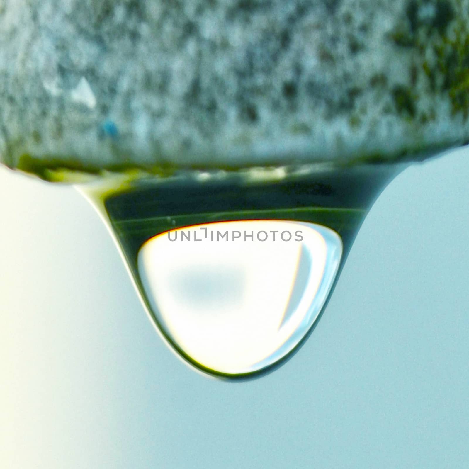 The round transparent drop of water falls downward by Emdaduljs