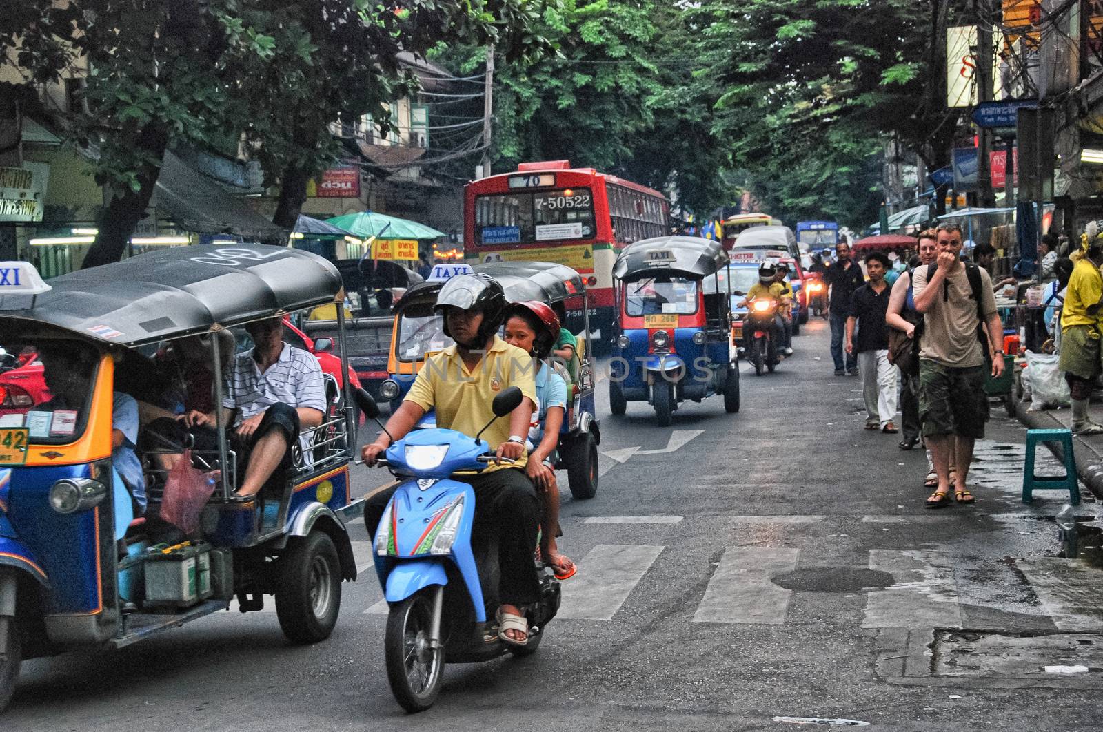 BANGKOK - AUG 23: A three wheeled tuk tuk taxi transports passen by jovannig