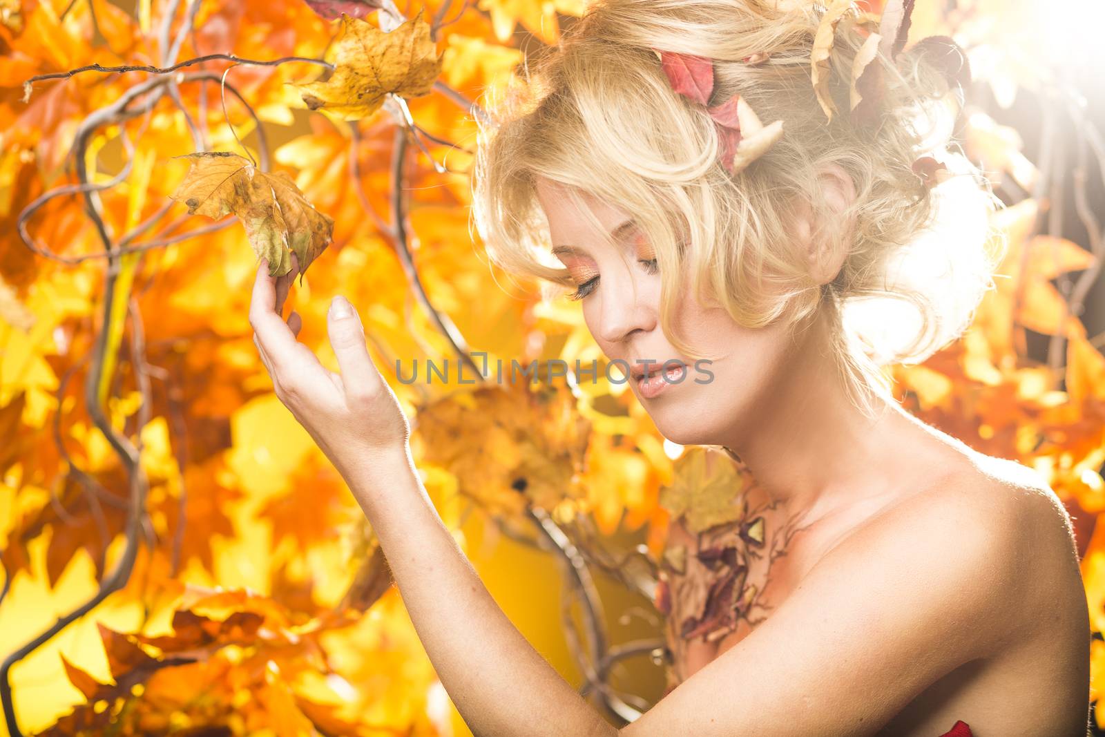 Fragile woman in autumn sun golden floral tree background