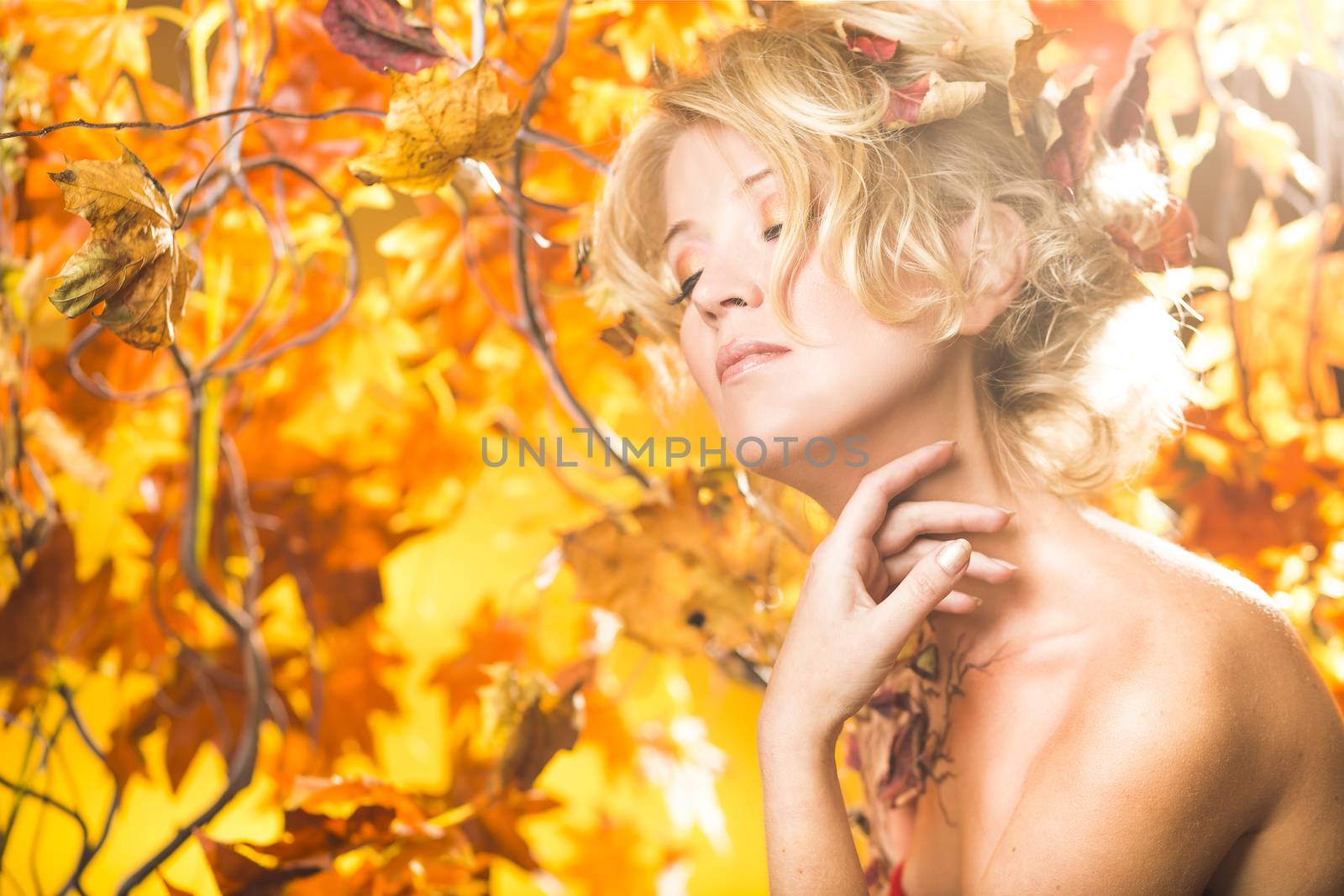 Fragile woman in autumn sun golden floral tree background