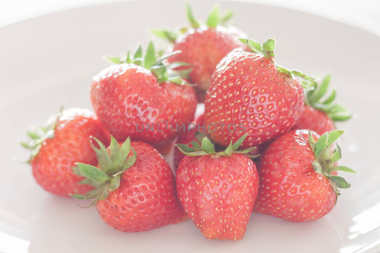 Fresh strawberries on white plate, stock photo