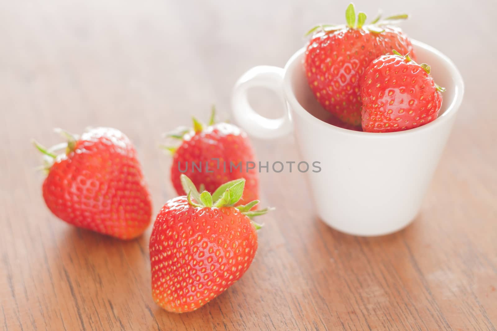 Fresh strawberries on wooden table, stock photo