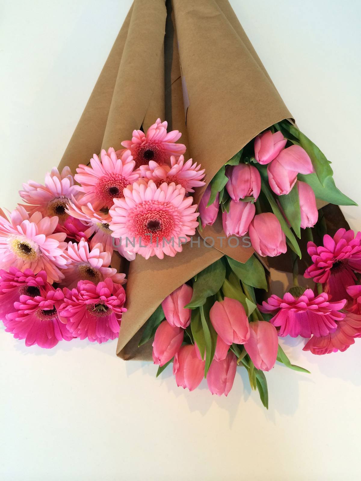 Variety of pink flowers wrapped in brown paper