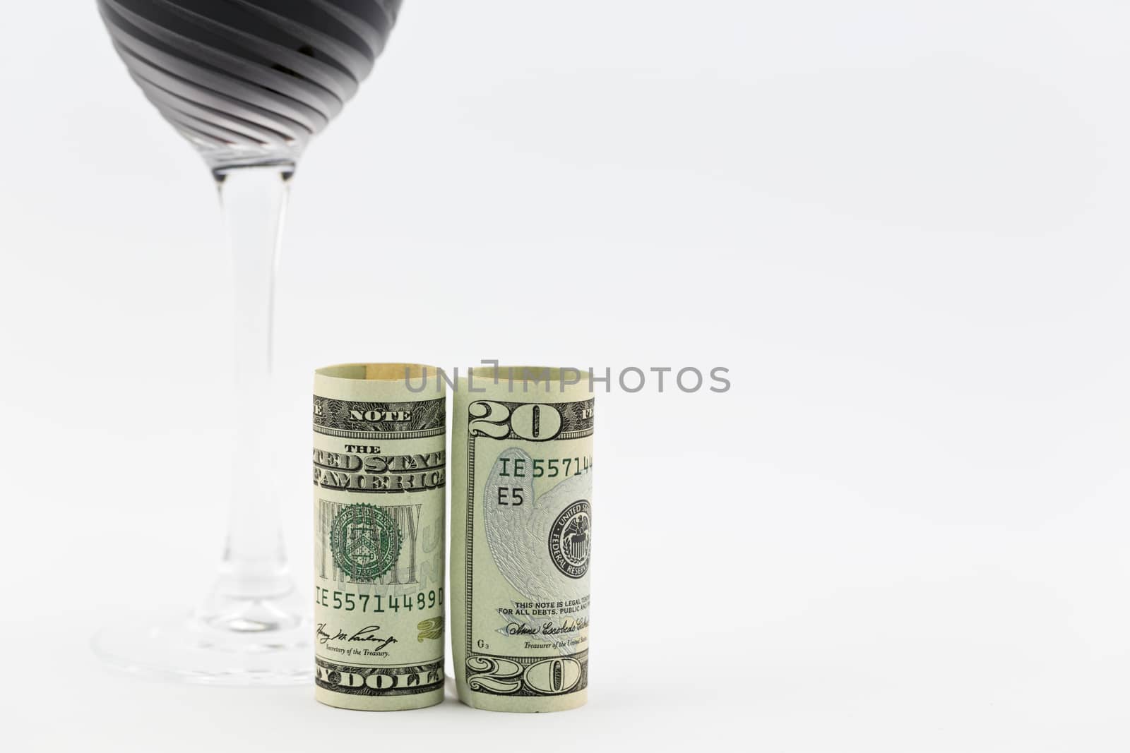 American money placed with stem glass filled with red wine; copy space on right; 