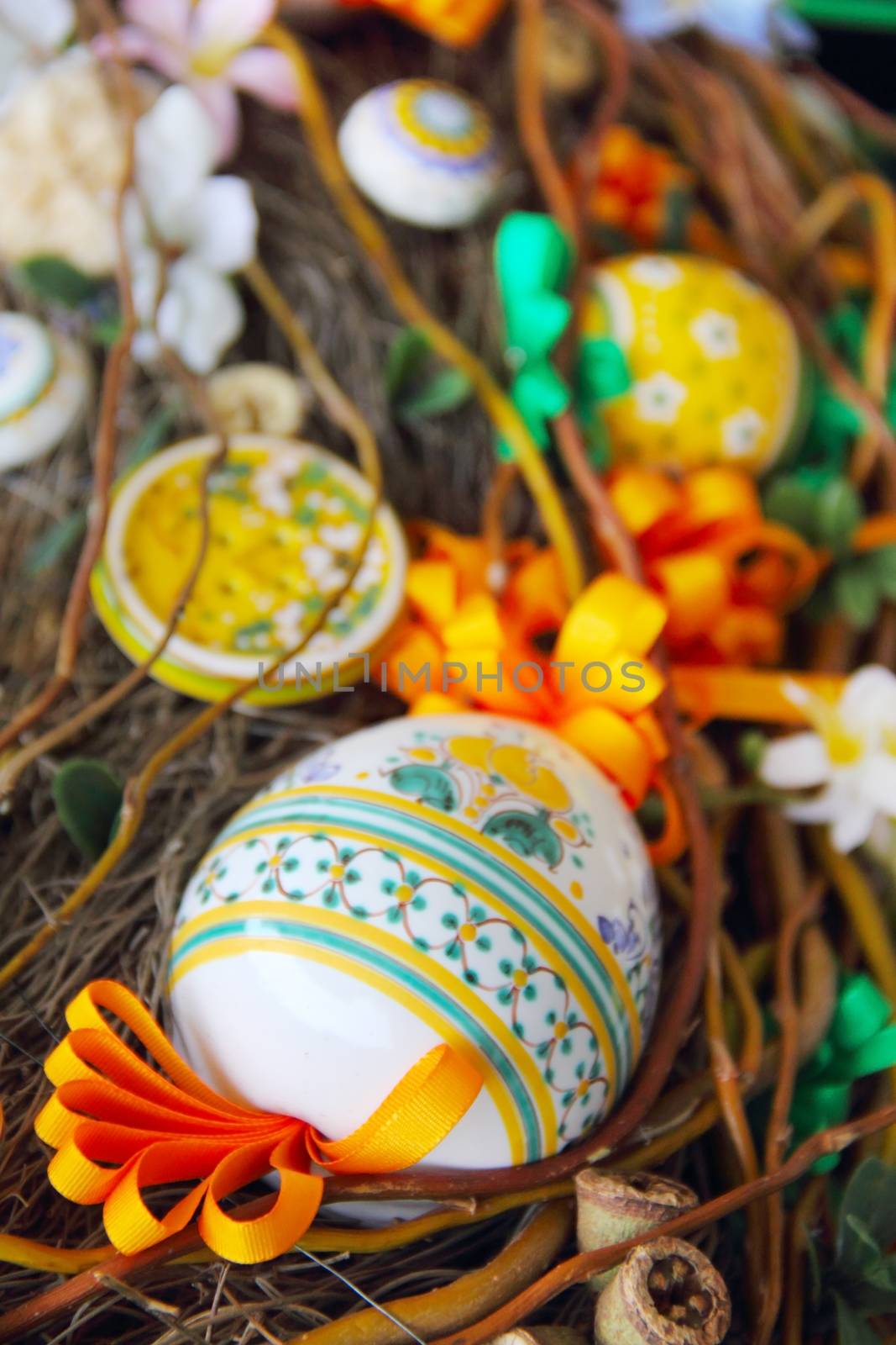Easter composition with eggs, bird, ribbons and flowers in nest
