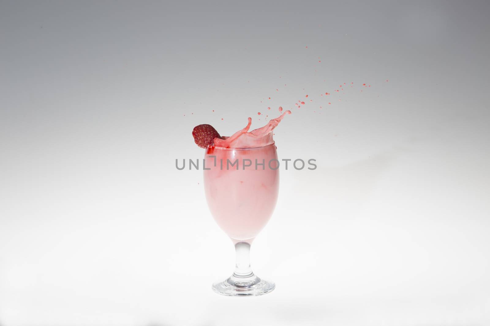 splash of milk strawbery in a glass shot in studio