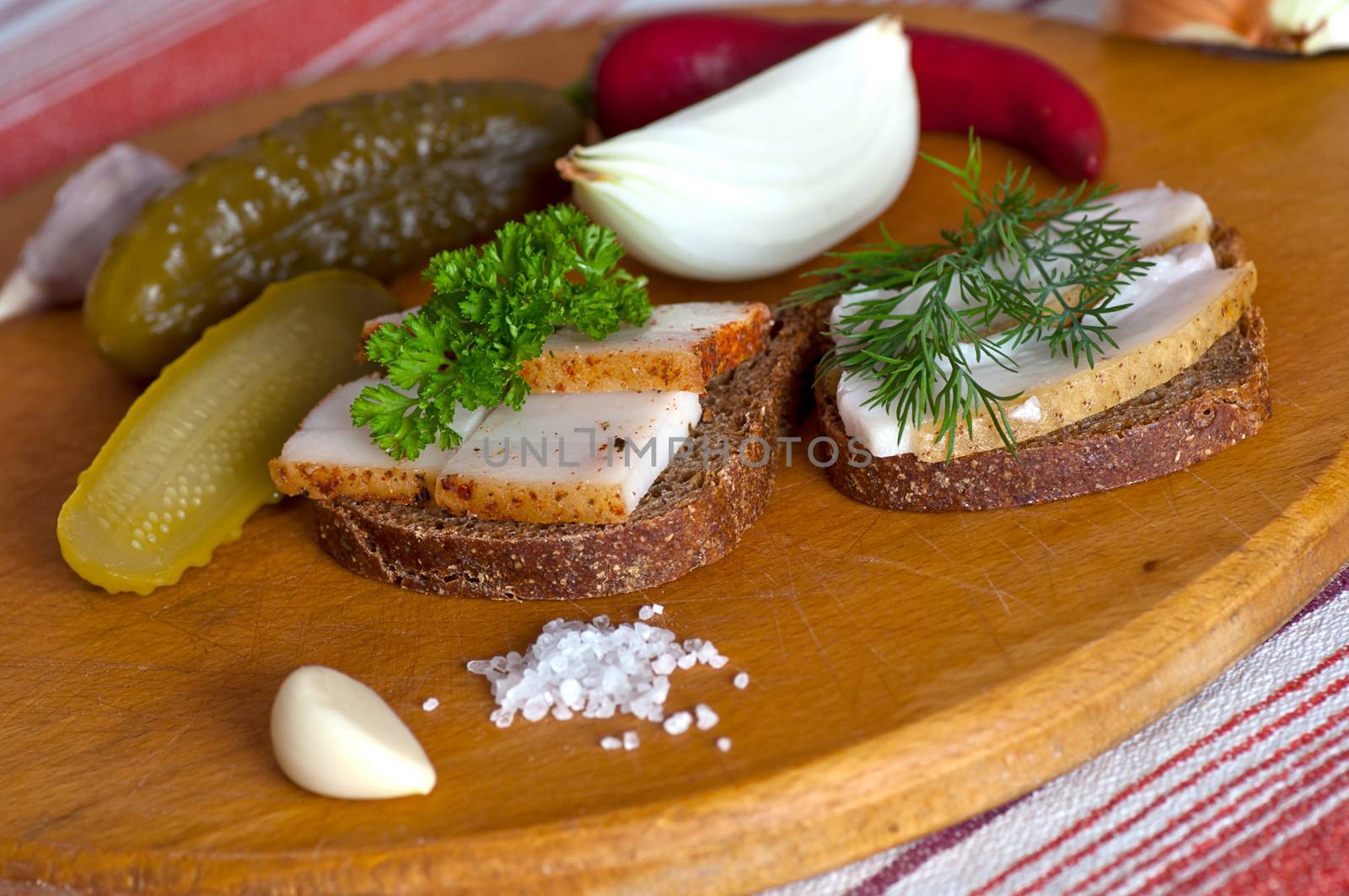 Sandwiches with salted and spiced lard served with onion, garlic and red pepper