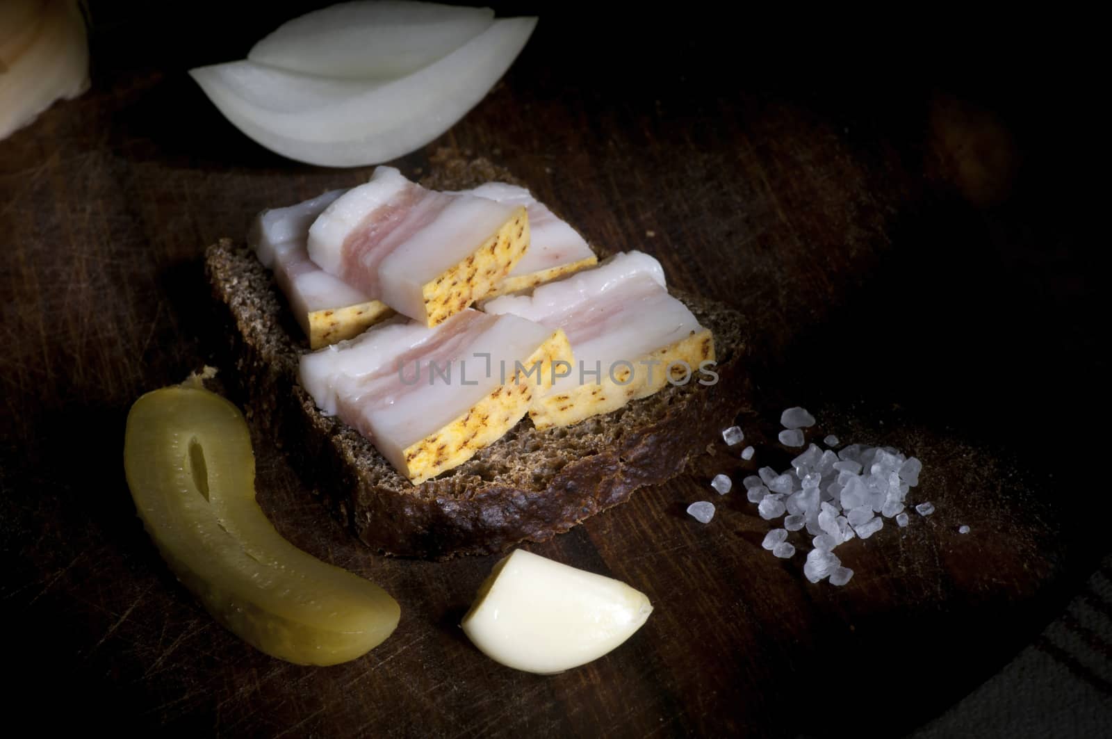 Sandwich with salted lard, served with onion, cucumber and garlic