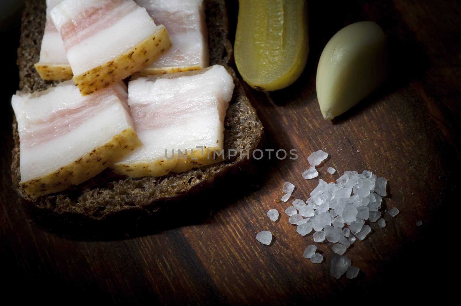 Sandwich with salted lard, served with onion, cucumber and garlic