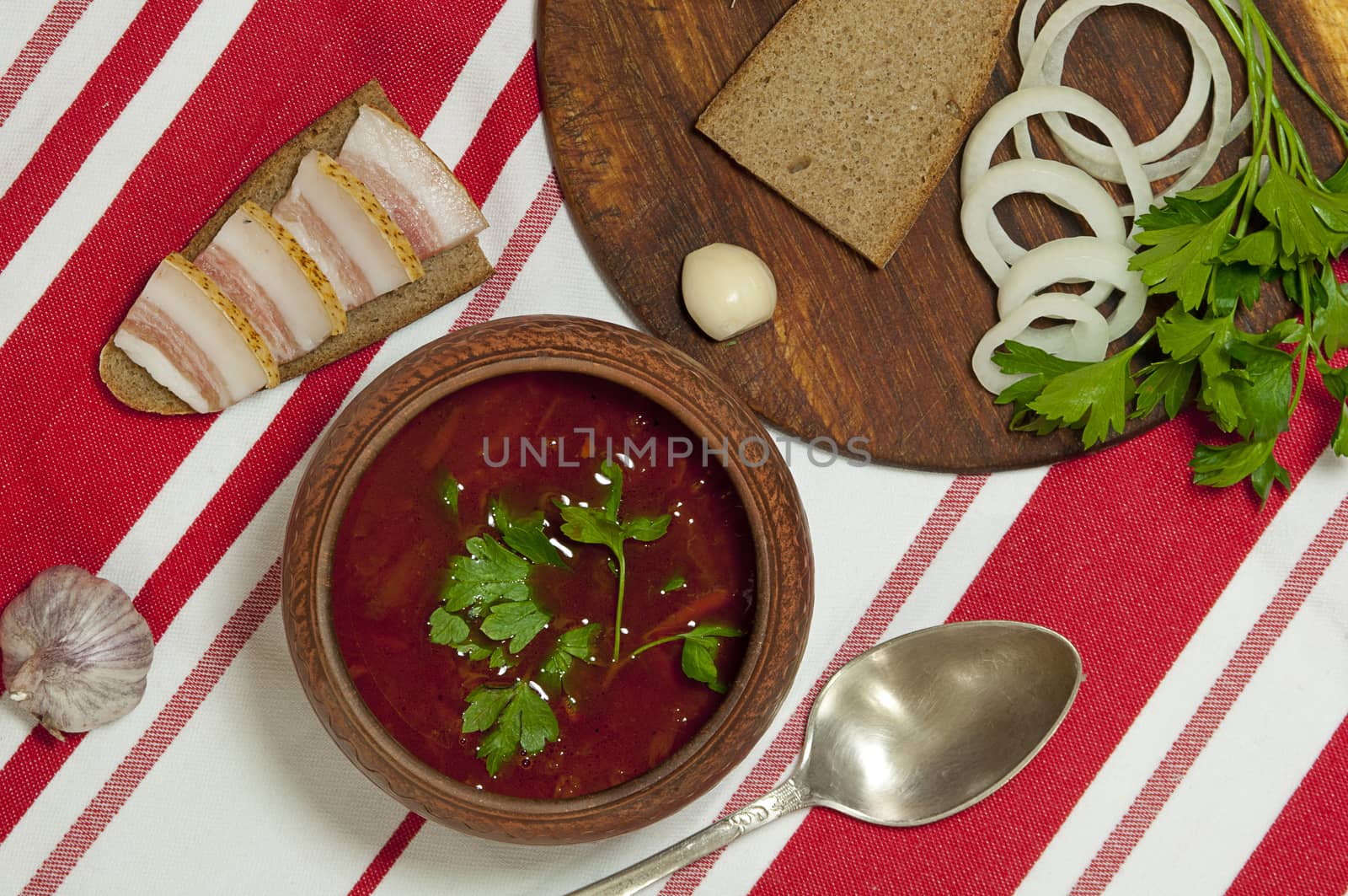 Traditional Ukrainian soup in pottery served with salted lard on rye bread