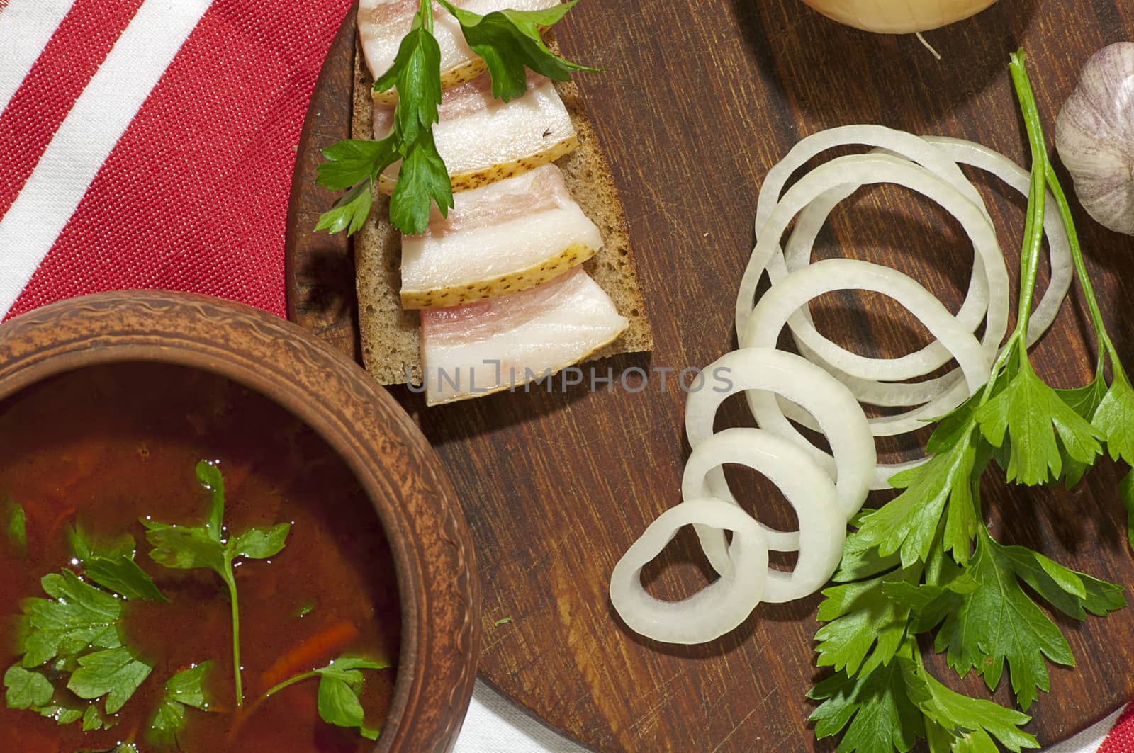 Traditional Ukrainian soup in pottery served with salted lard on rye bread