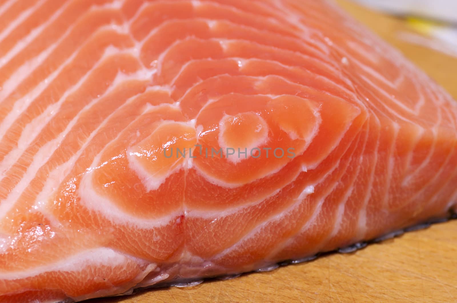 Fresh salmon fillet salted with coarse sea salt close up