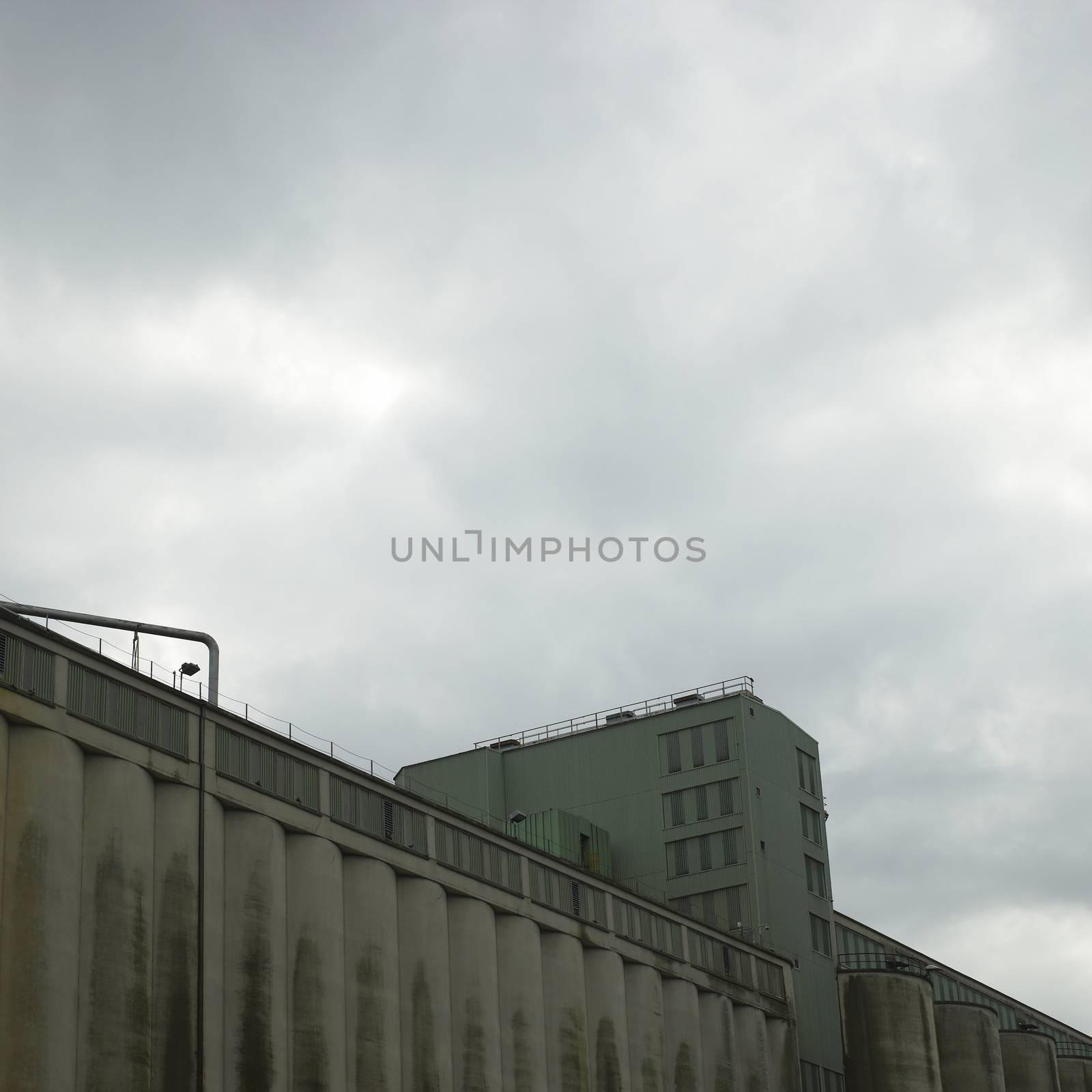 Large dark factory against grey sky