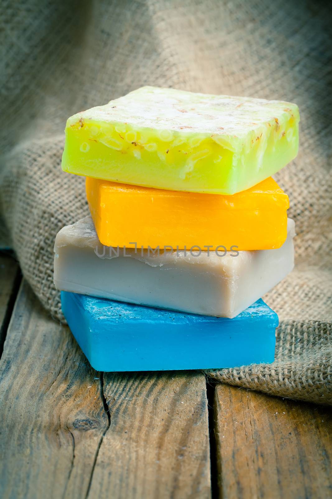 colorful handmade soap bars, on wooden background by motorolka