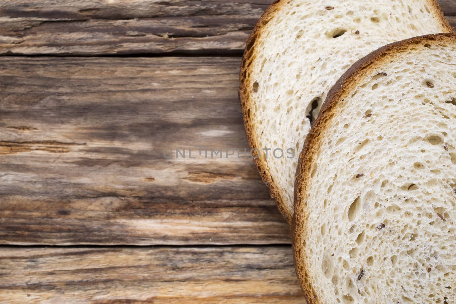 Slices of bread on a wooden background.
