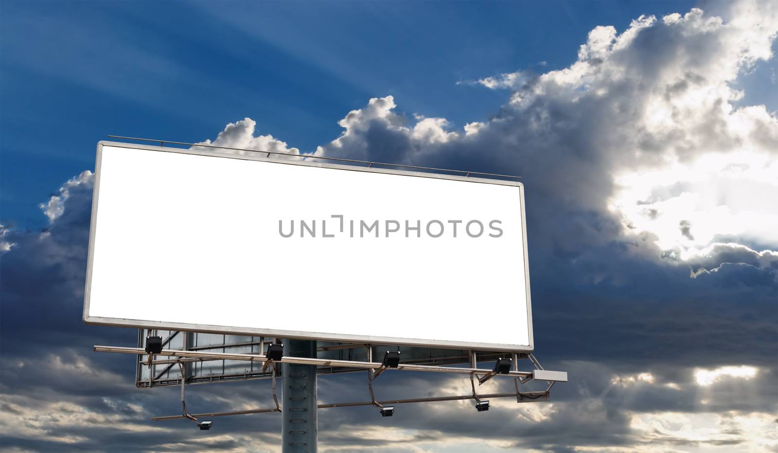 Billboard Blank Screen in front of beautiful cloudy sky with sun-rays