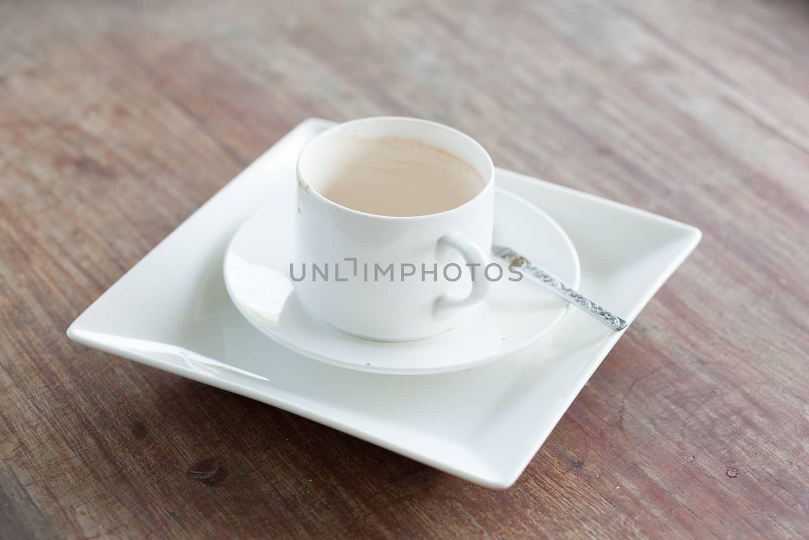 Coffee cup and white plates. Eating out and stacked on a wooden table.