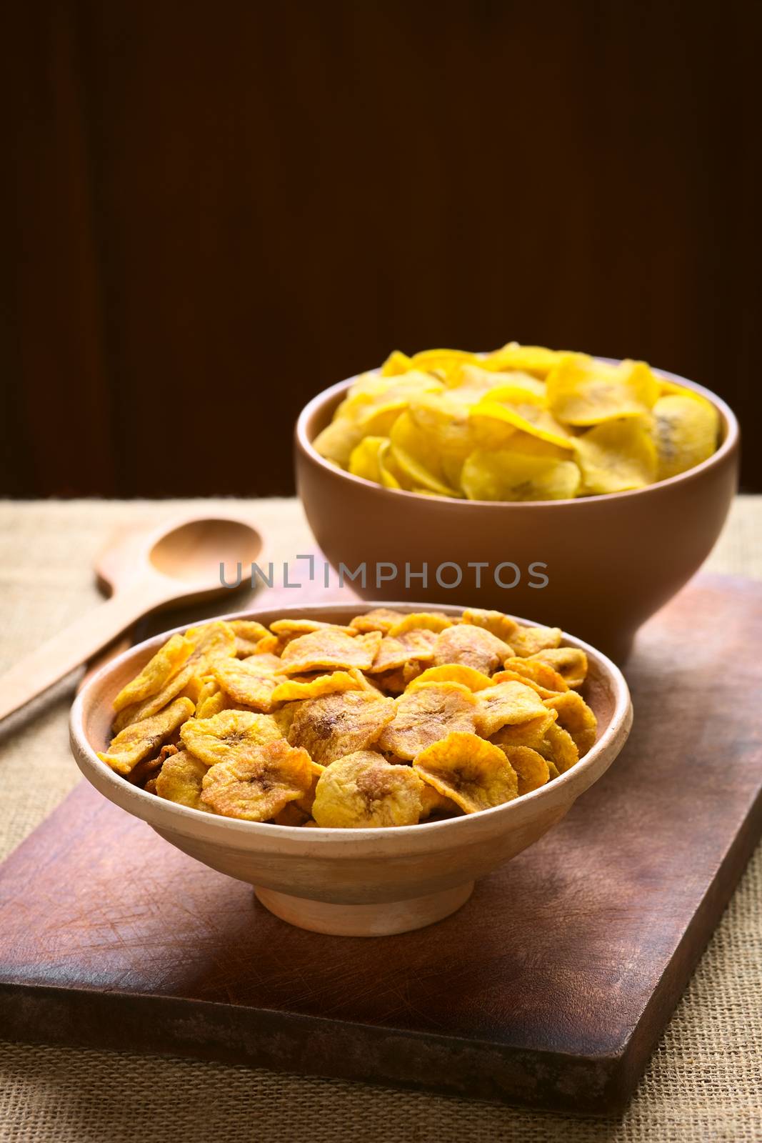 Bowls of sweet (front) and salty (back) plantain chips, a popular snack in South America photographed with natural light (Selective Focus, Focus one third into the first bowl) 