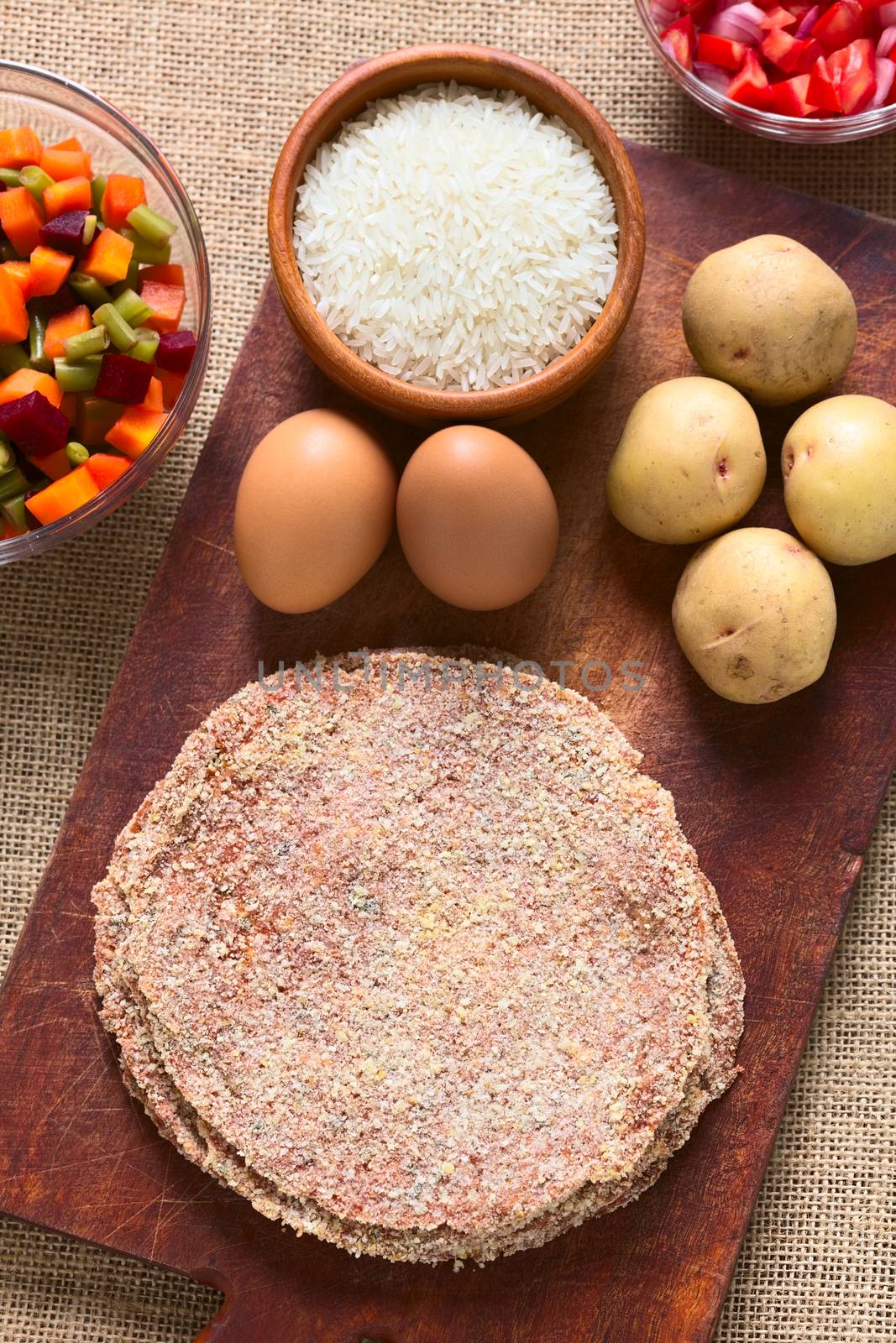 Traditional Bolivian meat called Silpancho, which is a breaded flat, round piece of beef meat, served with fried egg, rice, fried potatoes and vegetables (carrot, bean, beetroot), photographed with natural light 