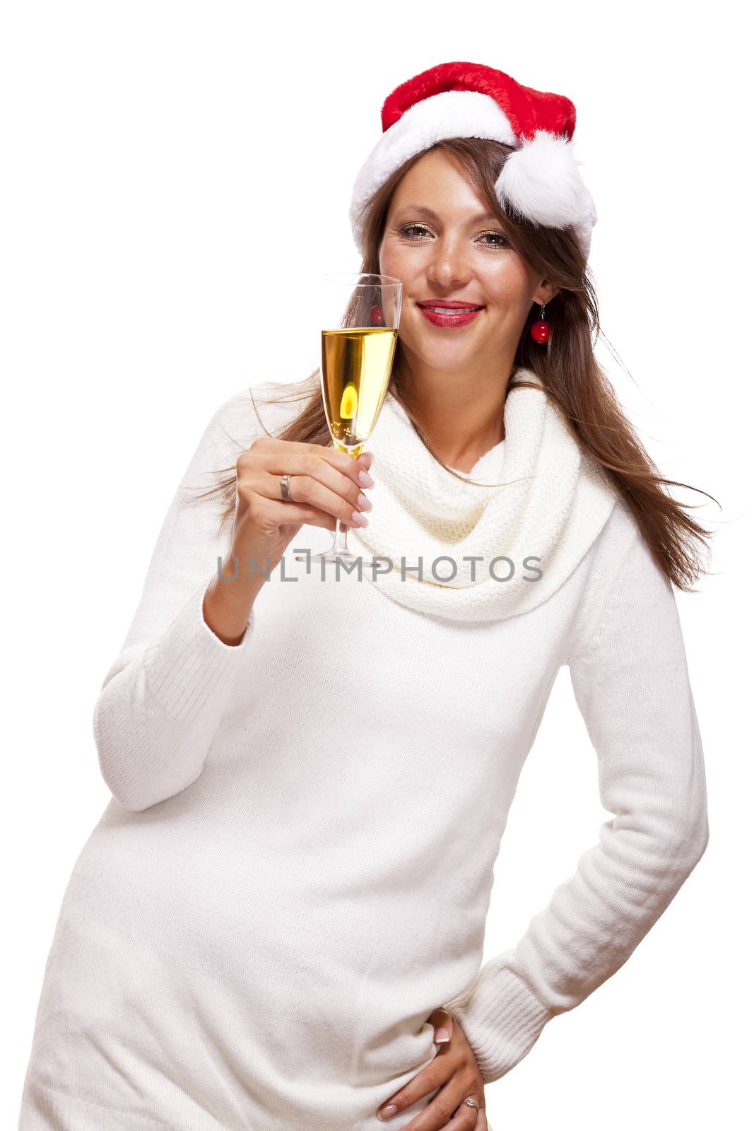 Playful woman wearing a festive red Santa hat and holding a flute of champagne celebrating Christmas blowing a kiss across the palm of her hand with a mischievous smile, on white