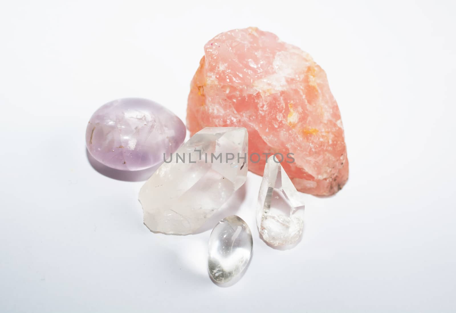 Quartz rocks. Group of semi-precious quartz, amethyst, rose quartz, pointed crystals on white background.