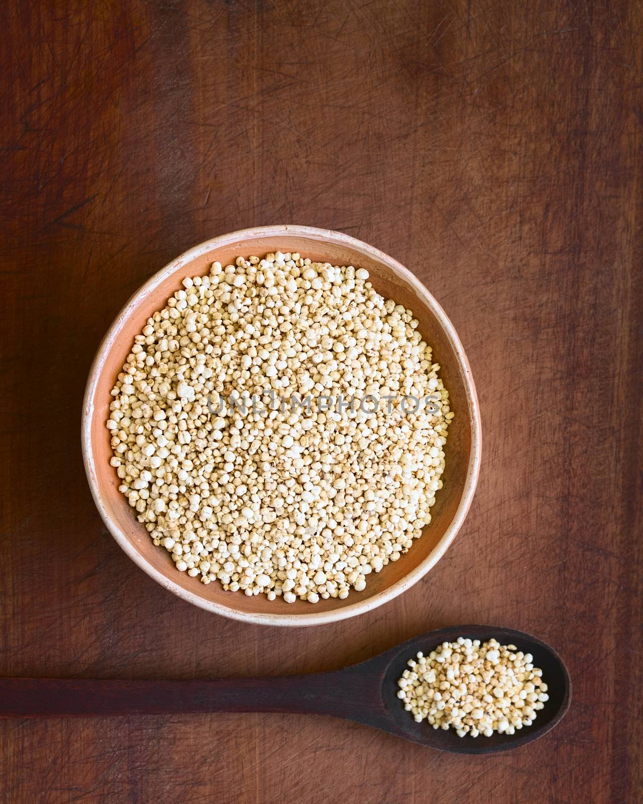 Overhead shot of popped white quinoa (lat. Chenopodium quinoa) cereal in bowl, photographed with natural light (Selective Focus, Focus on the popped quinoa in the bowl)