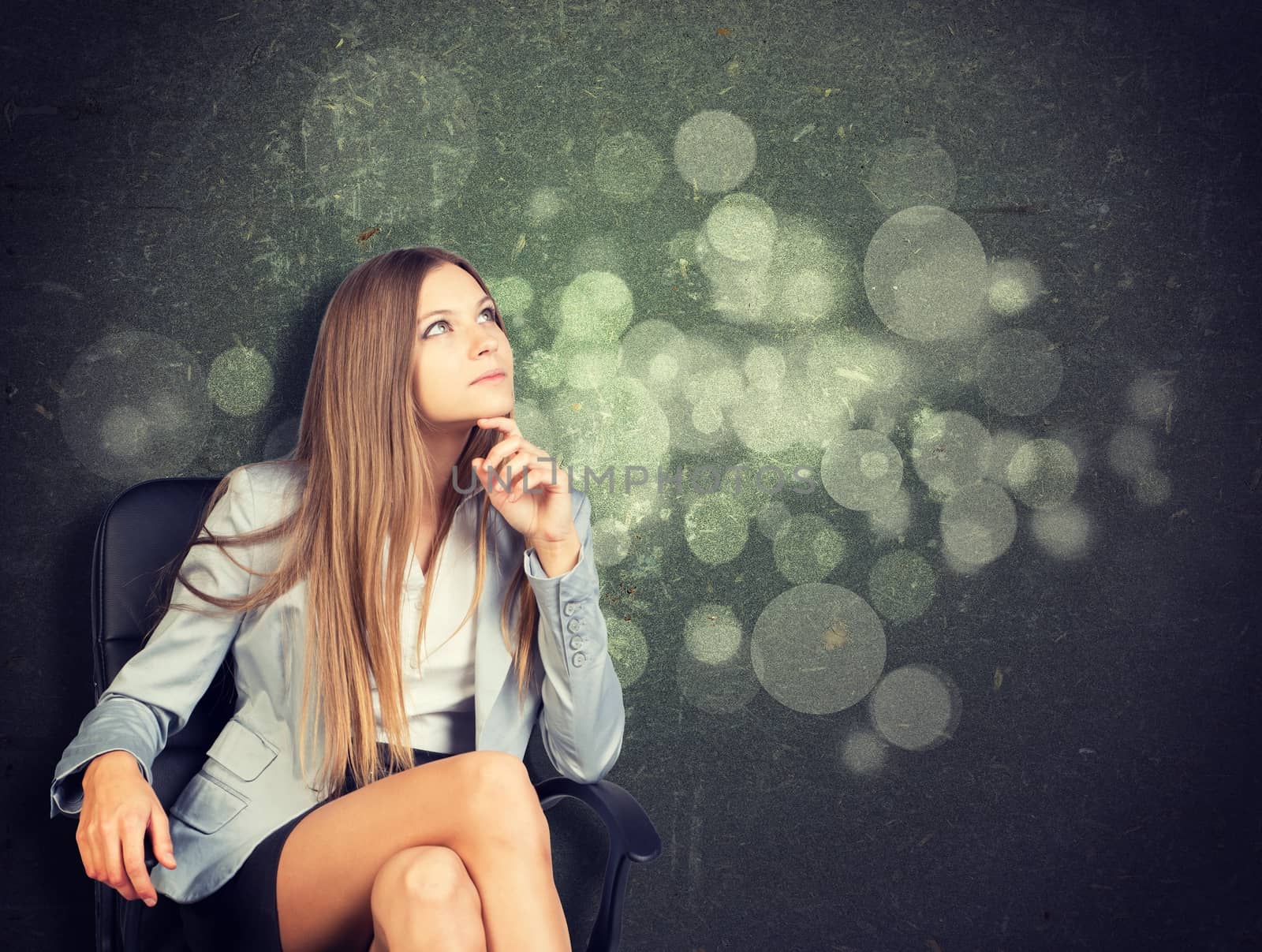 Woman in jacket, blouse sits on chair and looking up. Abstract background by cherezoff