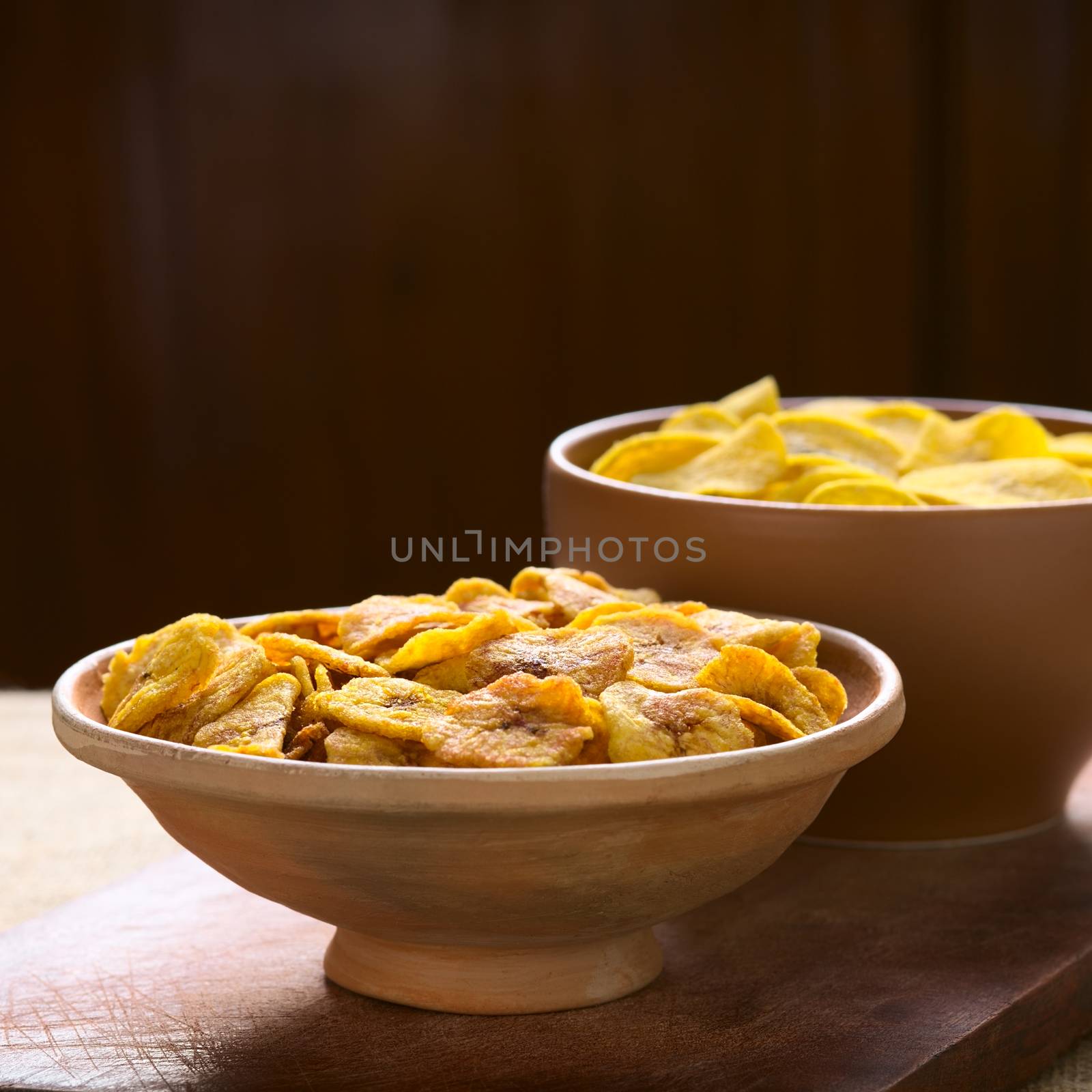 Bowls of sweet (front) and salty (back) plantain chips, a popular snack in South America photographed with natural light (Selective Focus, Focus one third into the first bowl) 