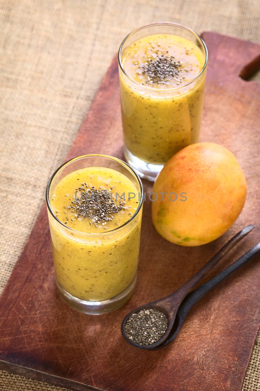 Chia seed (lat. Salvia hispanica) and mango juice photographed with natural light. Chia seeds are considered a superfood containing proteins, omega fats, minerals and antioxidants (Selective Focus, Focus on the chia seeds on the drink)