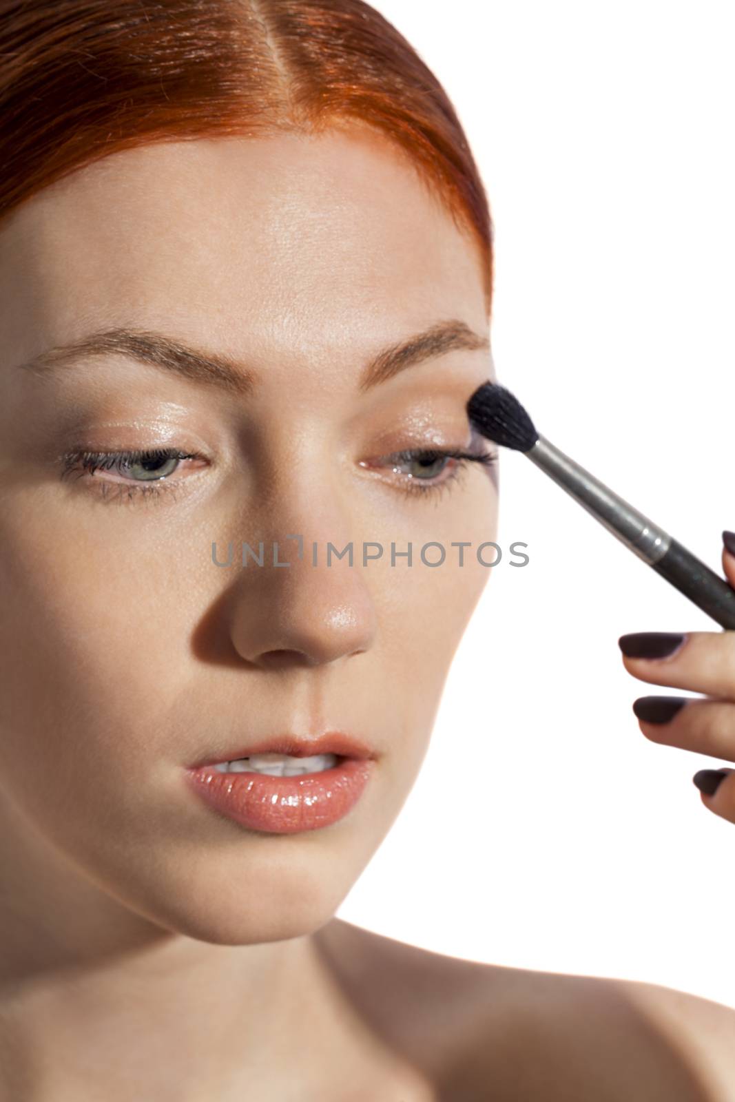 Close up Pretty Woman Applying Eye Shadow Makeup Using Brush on White Background.