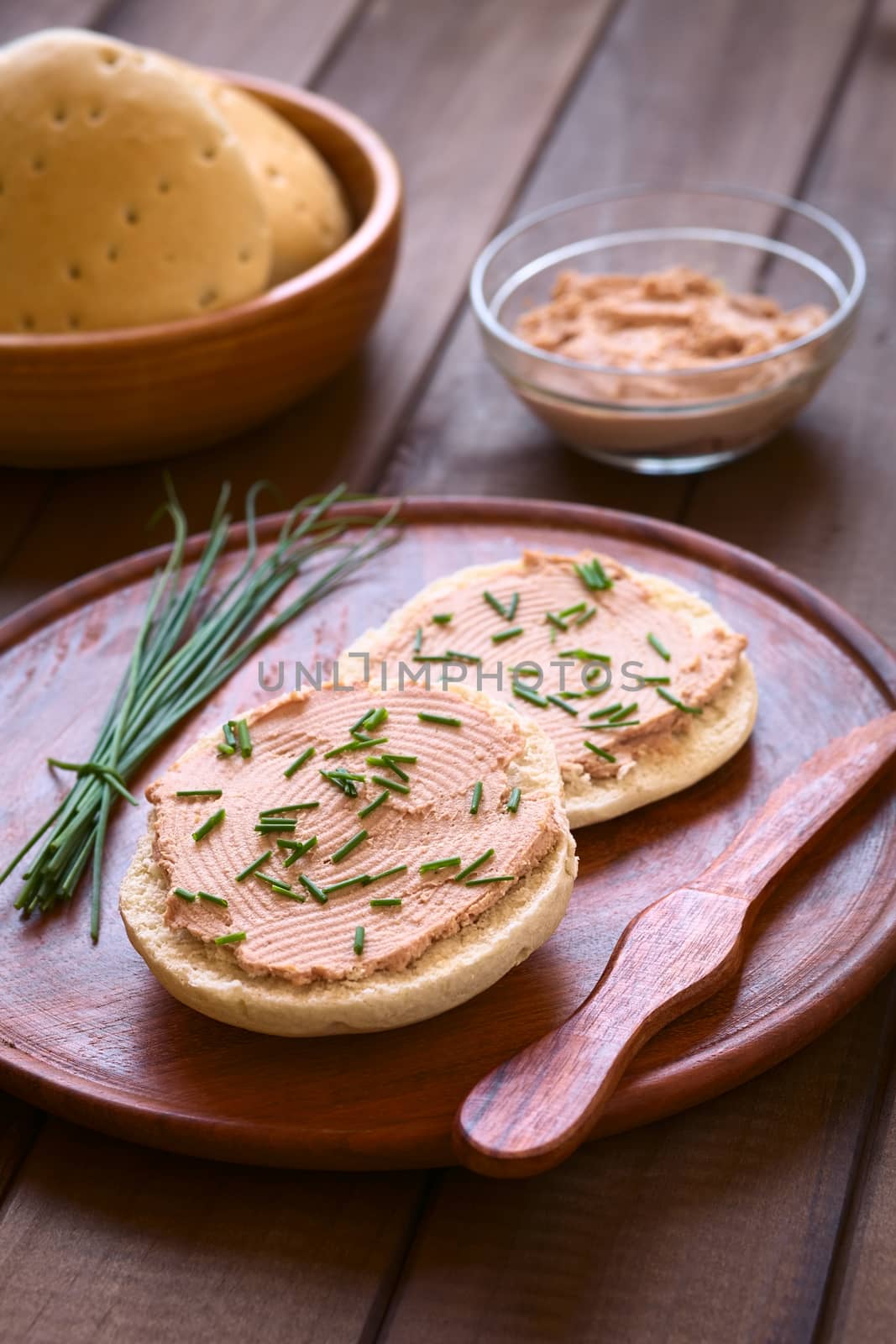 Liverwurst spread on bun with chives photographed with natural light (Selective Focus, Focus one third into the bun)