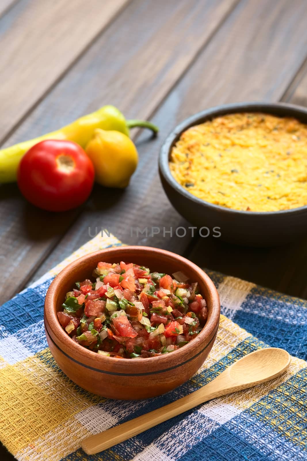 Traditional Chilean Pebre sauce made of tomato, onion, aji verde (small green hot pepper), lemon juice and coriander leaves served for barbecue and traditional dishes, photographed on wood with natural light (Selective Focus, Focus in the middle of the pebre)