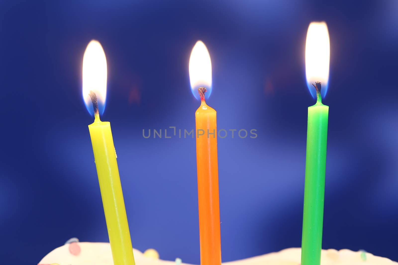 Three lit birthday candles close up, shallow dof