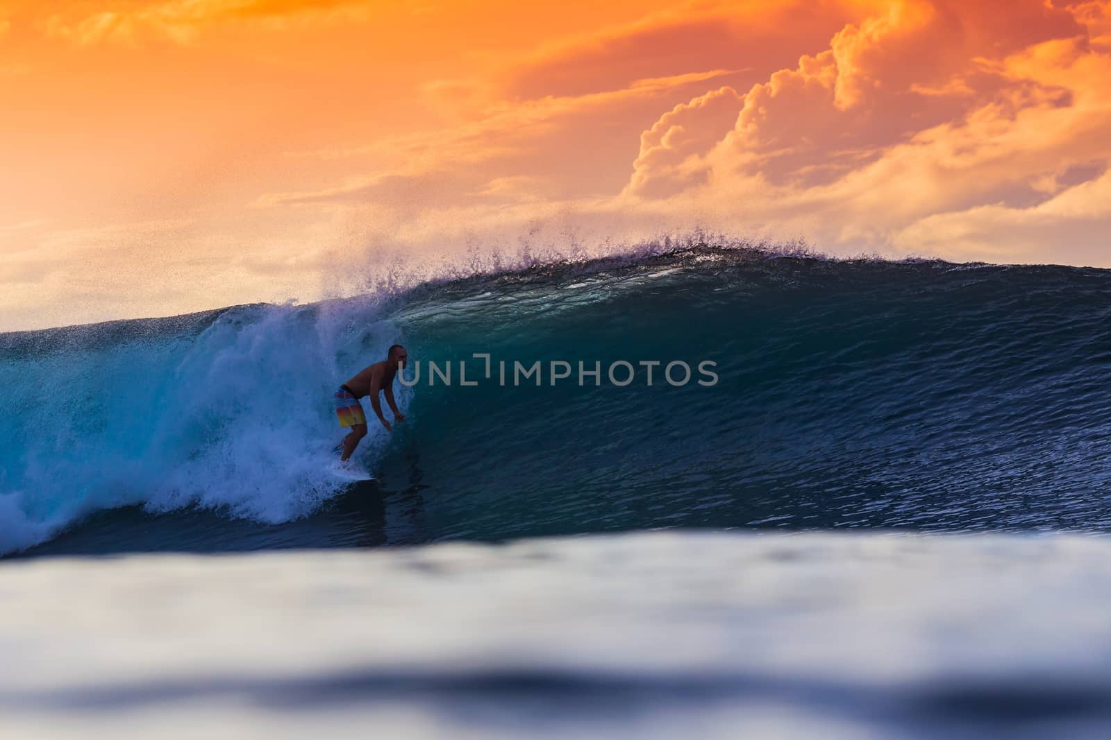 Surfer on Amazing Wave at sunset time, Bali island.