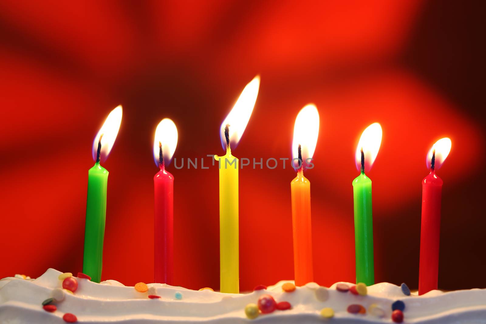 Six lit birthday candles close up, shallow dof