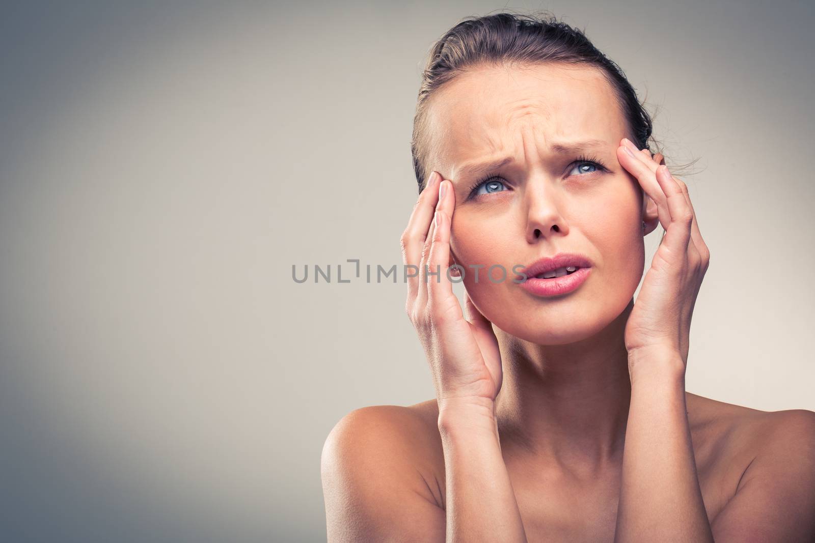 Gorgeous young woman with severe headache/migraine (color toned image)