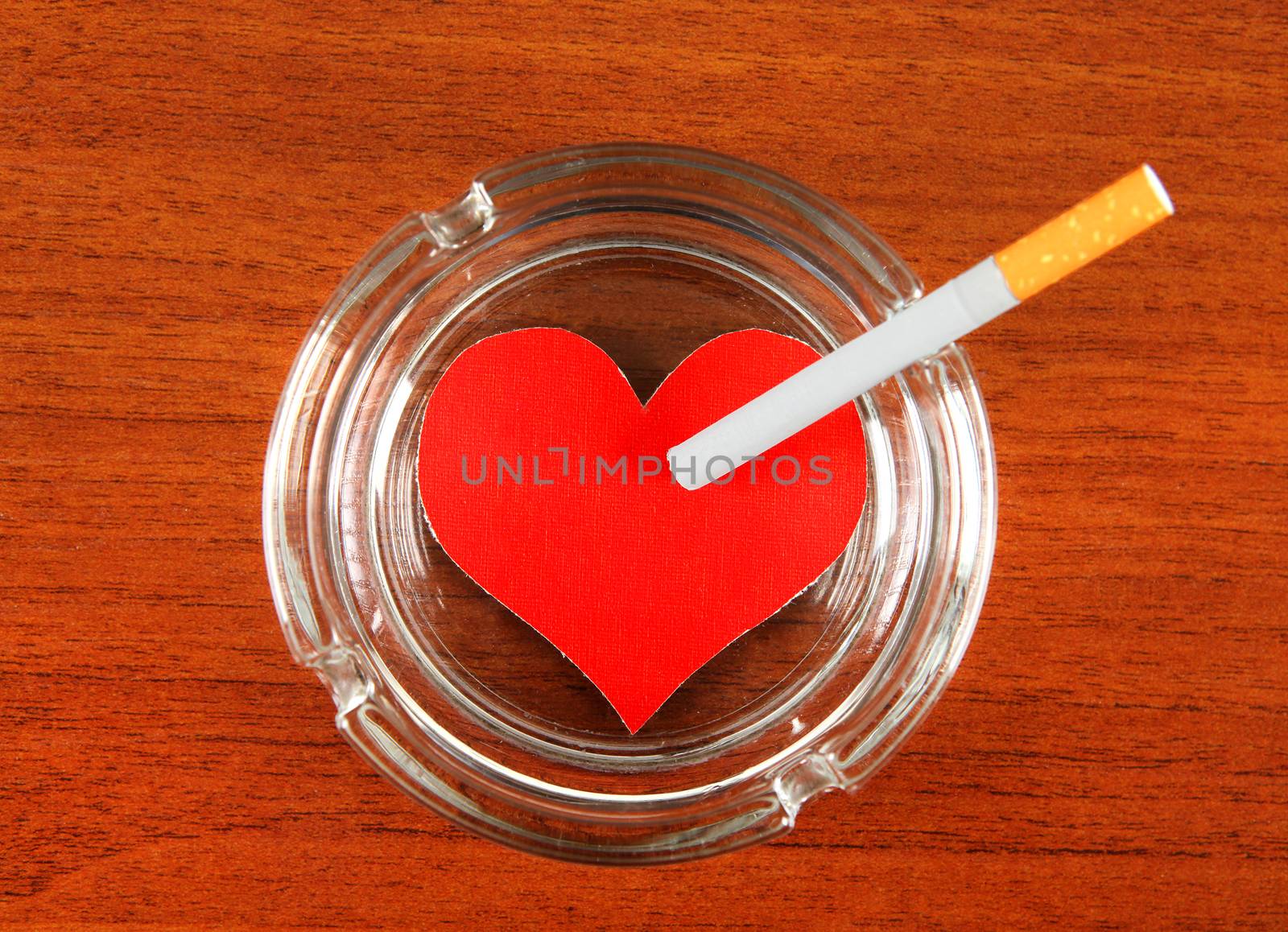 Cigarette in Ashtray with Heart Shape on the Table