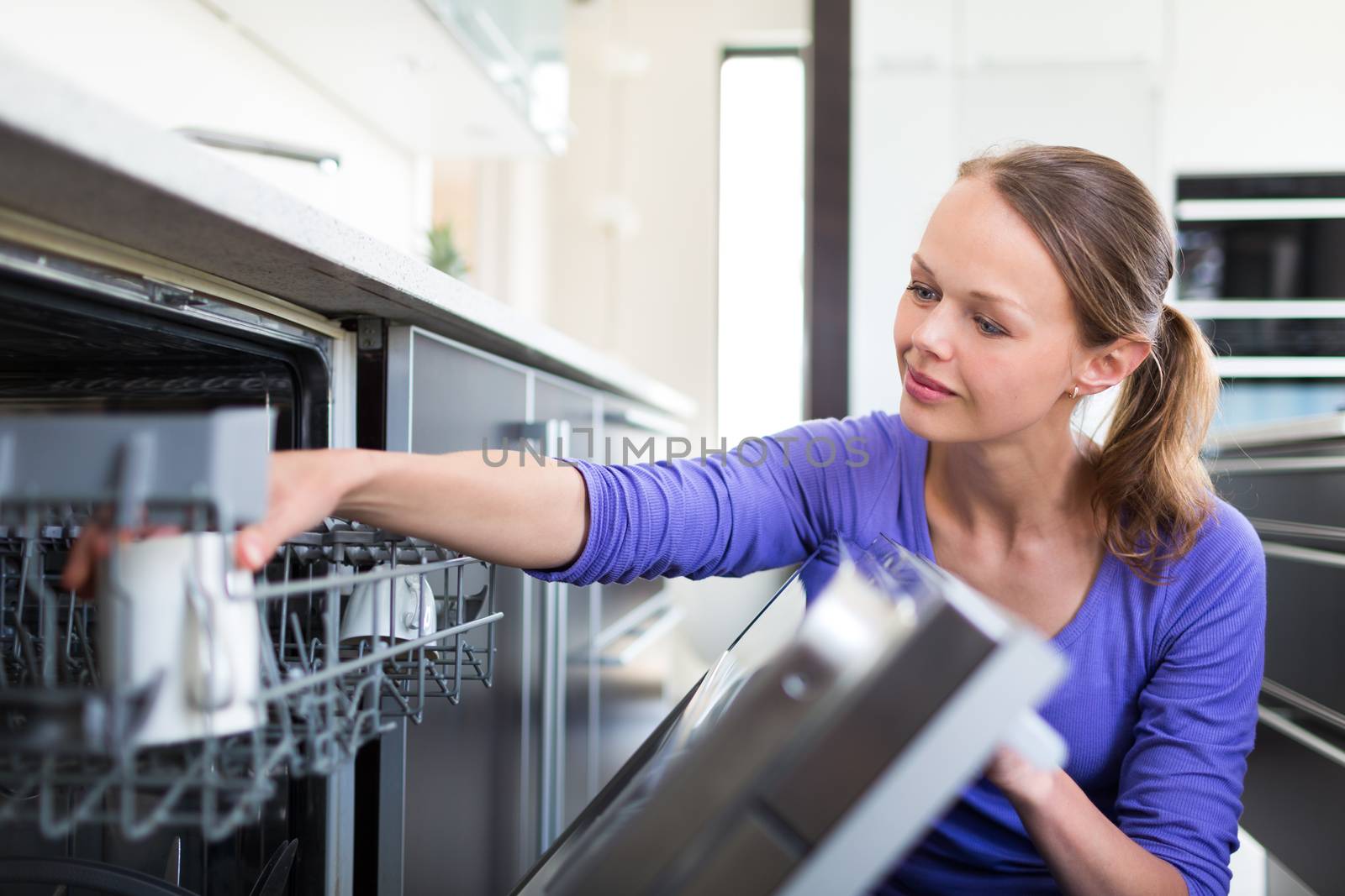 Housework: young woman putting dishes in the dishwasher by viktor_cap
