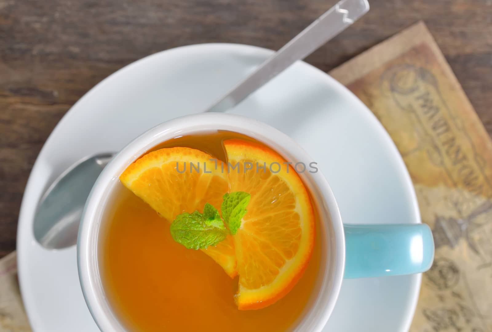 cup of tea and orange slices on old wood table