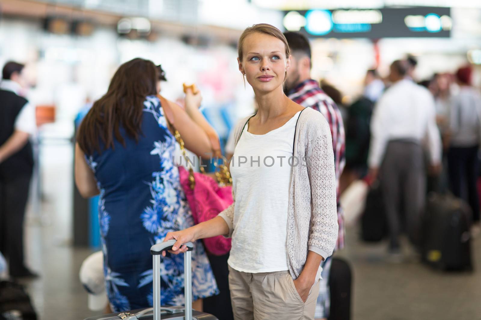 Young female passenger at the airport, about to check-in by viktor_cap