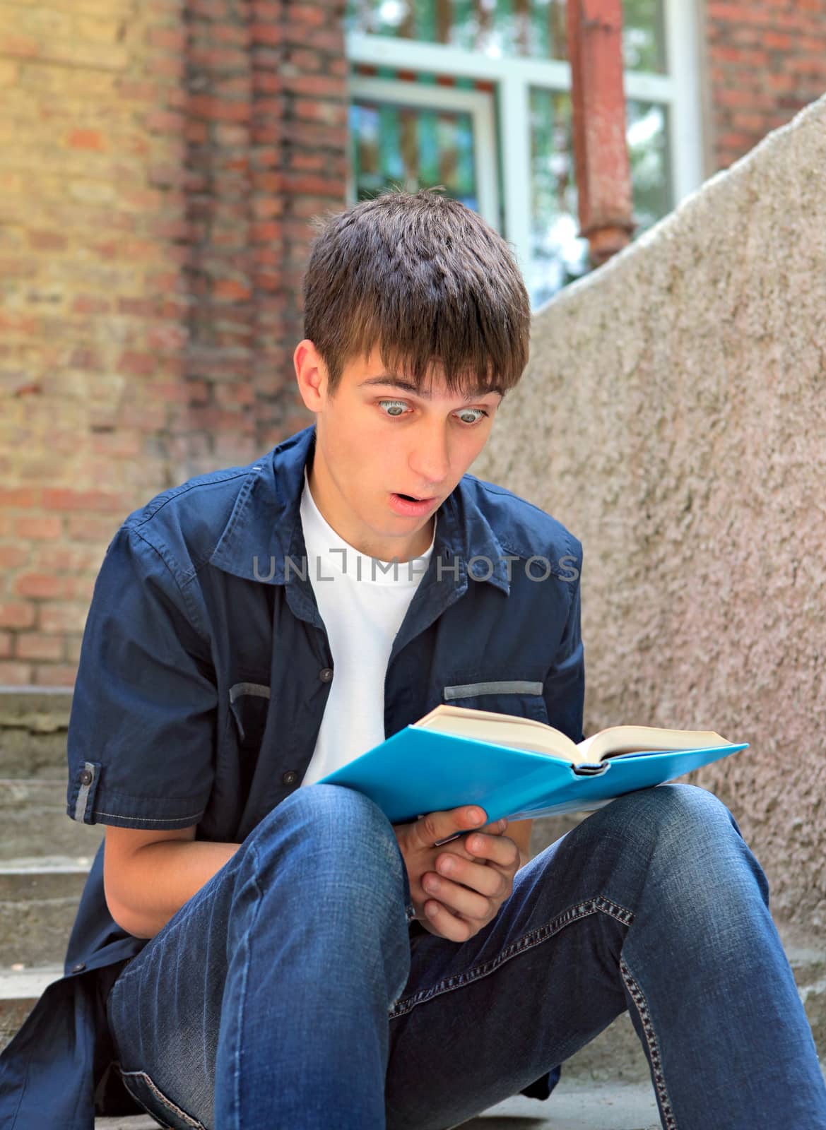 Surprised Teenager with the Book on the landing steps of the House