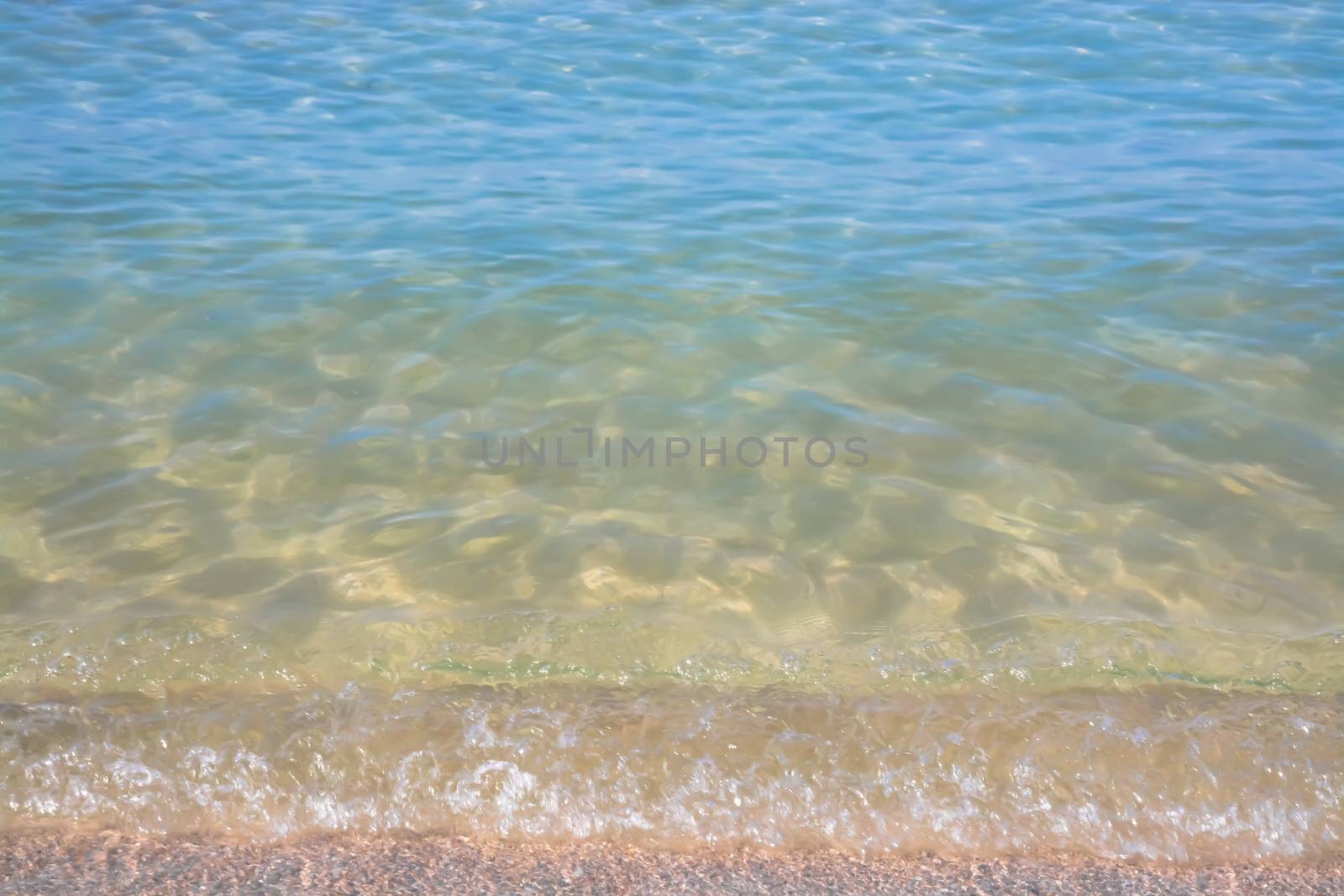 Waters edge. Closeup of sandy beach with crystal clear water, Mallorca, Balearic islands, Spain.