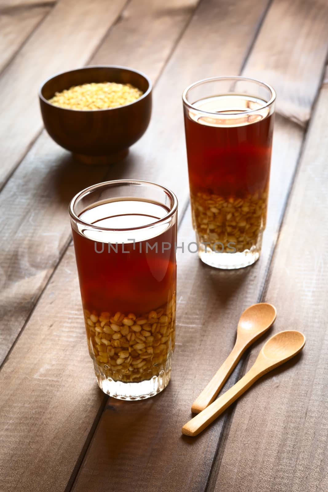 Traditional Chilean non-alcoholic cold drink called Mote (cooked husked wheat) con Huesillo (dried peach). The beverage is prepared by cooking the dried peach with sugar and cinnamon in water. (Selective Focus, Focus on the first drink)  