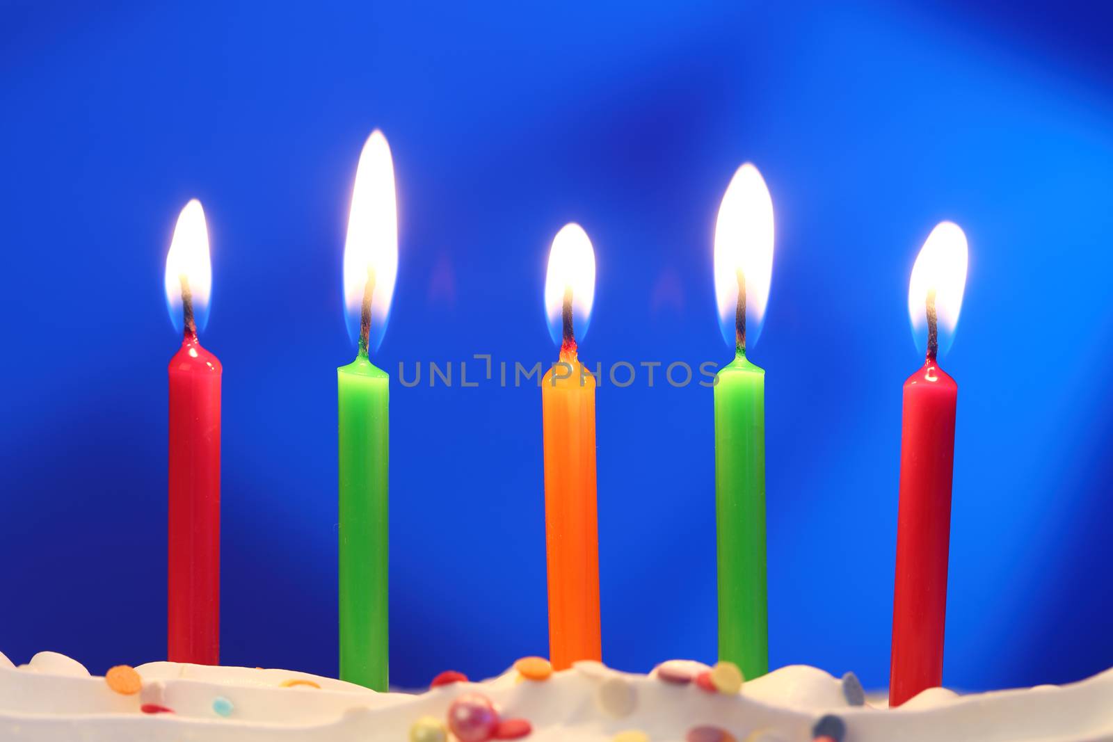 Five lit birthday candles close up, shallow dof