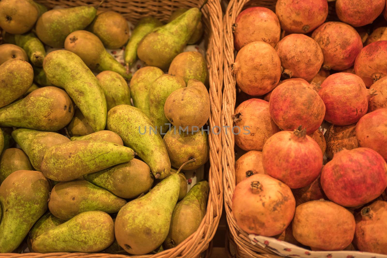 Counter with ripe pomegranates and pears in supermarket 