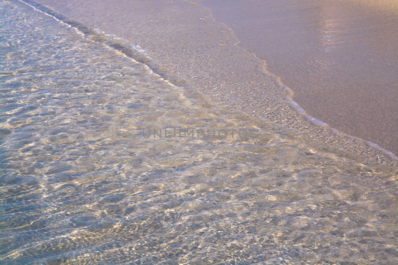 Waters edge. Closeup of sandy beach with crystal clear water, Mallorca, Balearic islands, Spain.