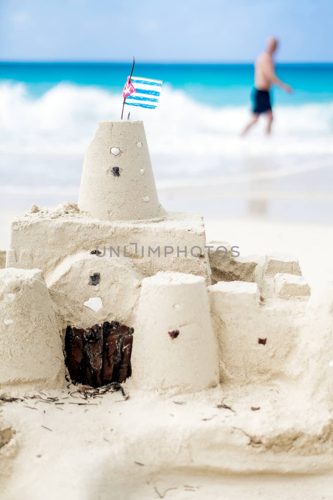 Cuban Sandcastle with the country Flag on one of the most Beautiful Beach of Cuba with a tourist in background